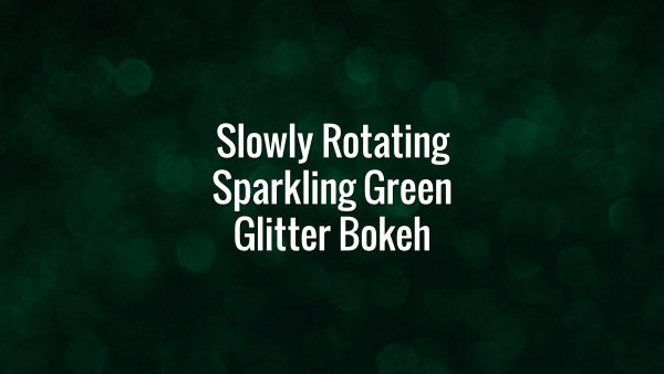 Seamlessly looping slowly spinning flickering green glitter bokeh particles on dark surface.